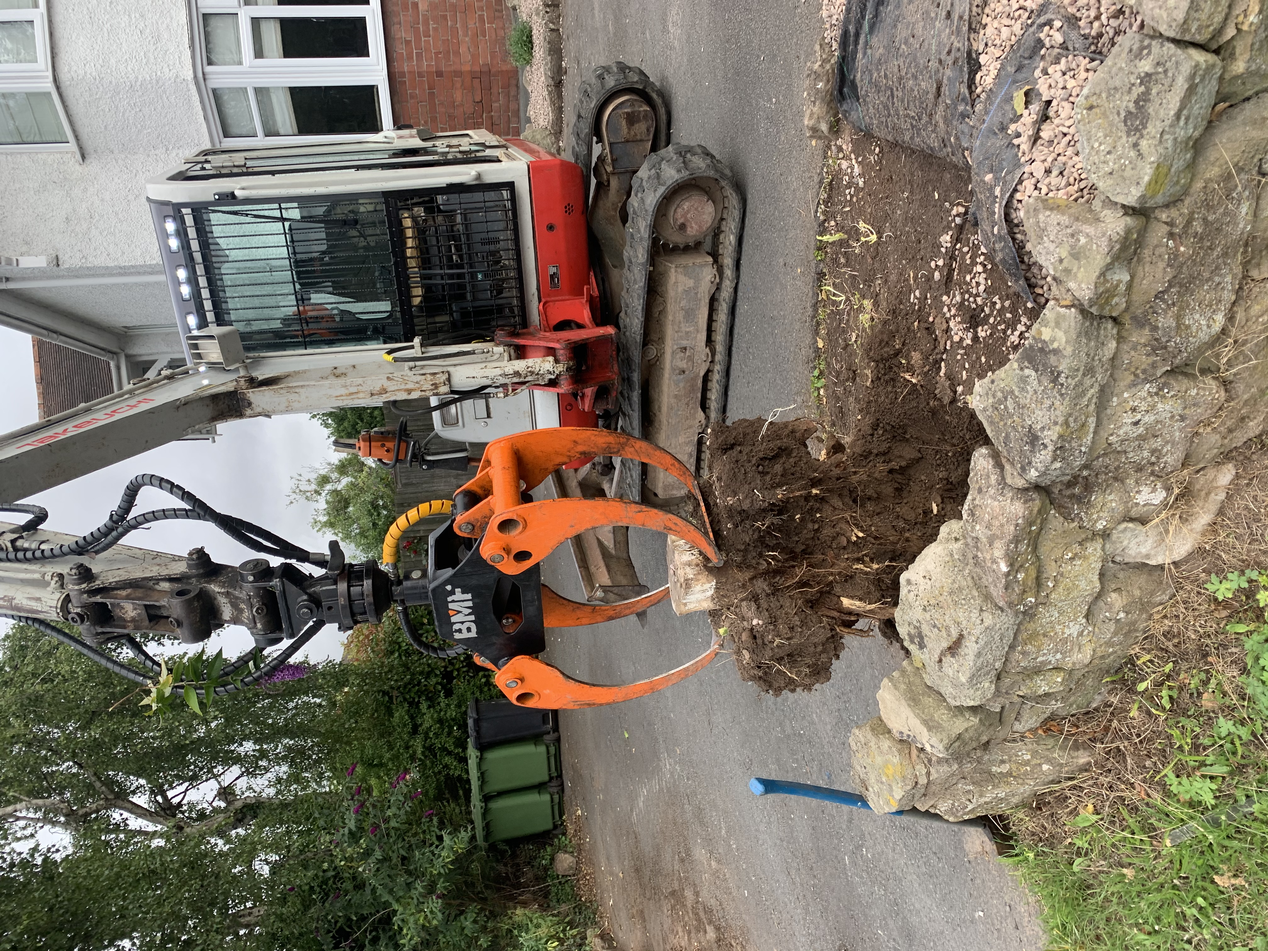 digger with grab pulling stump out